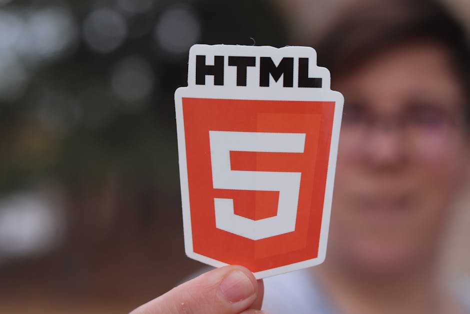 A close-up view of a computer screen displaying lines of HTML code, with a dark background and color-coded text in green, yellow, and white, indicating web development or coding activity.